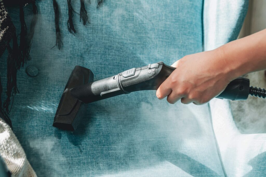 Hand cleaning a armchair with steam cleaner, Home cleaning conce